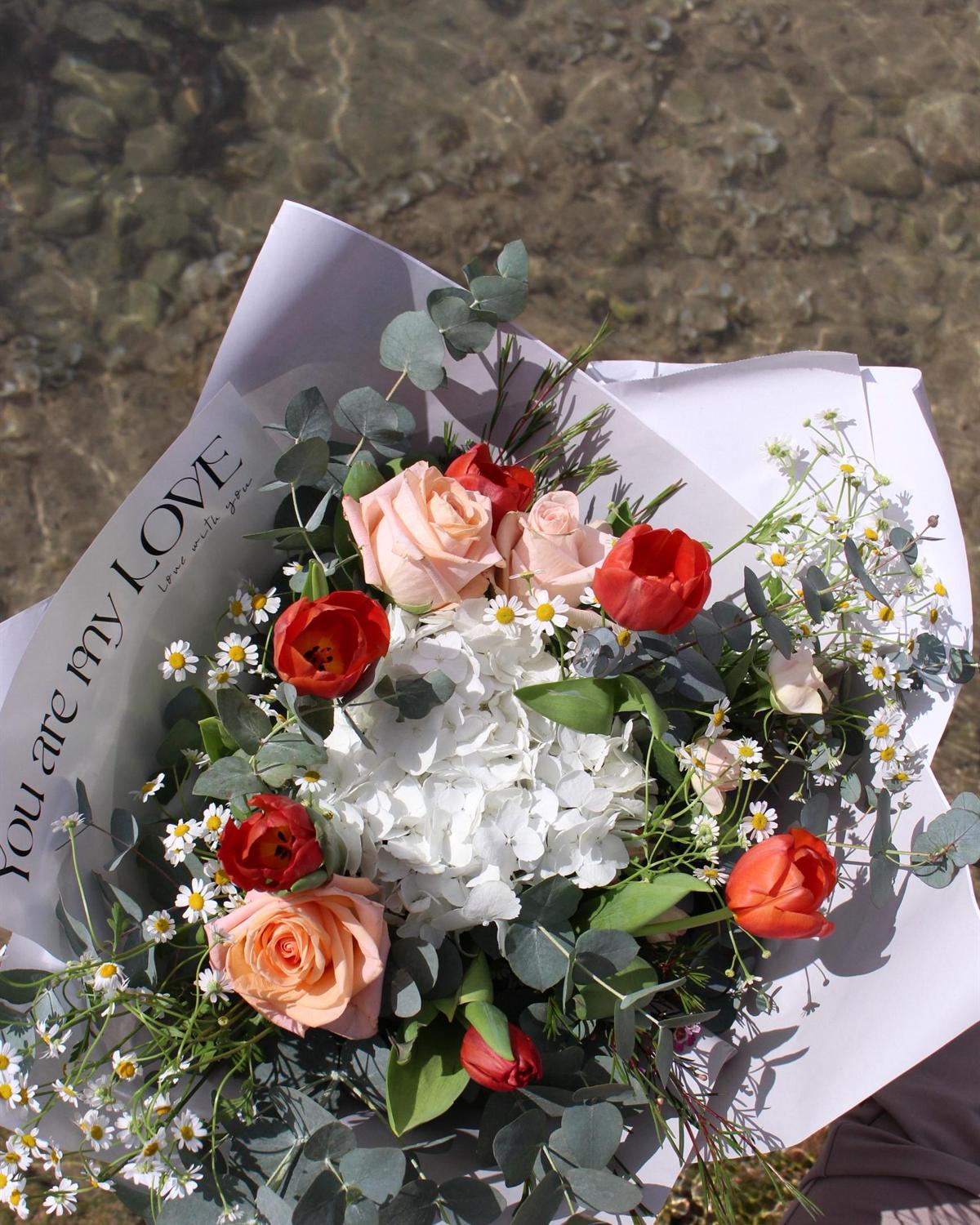 Ramo de hortensia blanca, tulipanes rojos, rosas melocotón y manzanilla de Floristería Las Lilas en Torrevieja